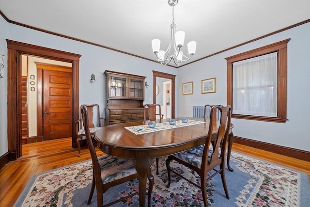 dining space featuring baseboards, a notable chandelier, and ornamental molding