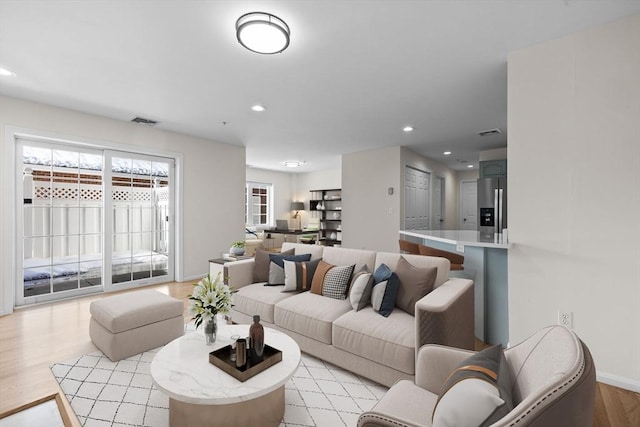 living room featuring a healthy amount of sunlight, light wood-style flooring, visible vents, and recessed lighting