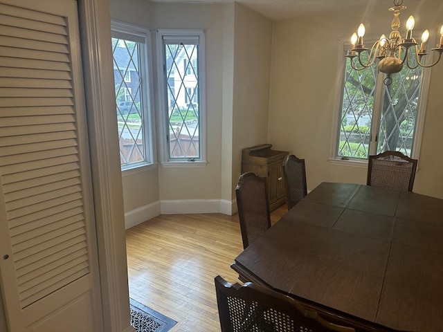 54 Brunswick Park, Melrose, MA 02176 - dining room with plenty of natural light, a chandelier, light wood-style floors, and baseboards