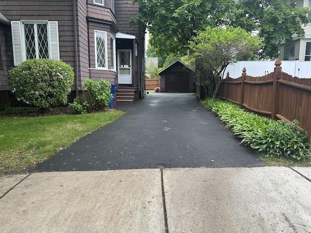 54 Brunswick Park, Melrose, MA 02176 - view of side of property featuring asphalt driveway, fence, an outbuilding, and entry steps