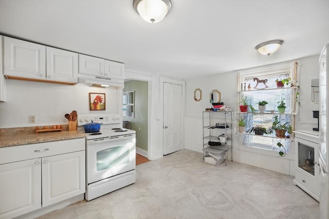 kitchen featuring a wealth of natural light, white cabinetry, and electric stove