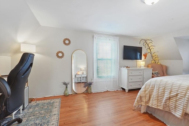 bedroom featuring light hardwood / wood-style flooring and lofted ceiling