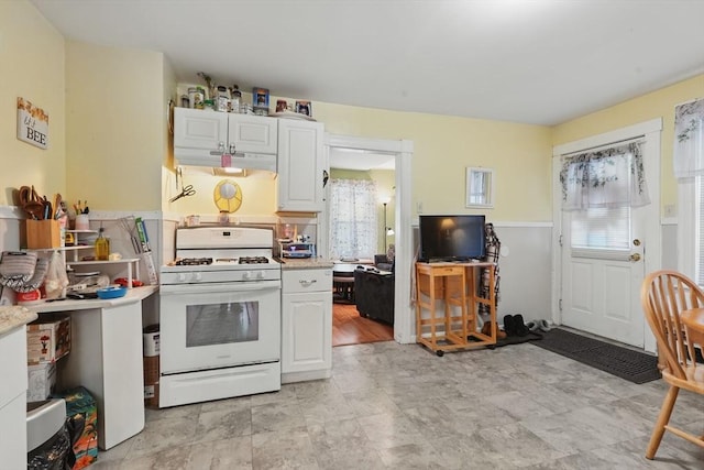 kitchen with white cabinets, gas range gas stove, and plenty of natural light