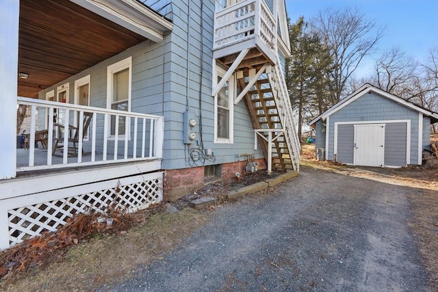 view of side of home with covered porch and a storage unit