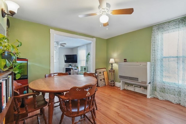 dining area featuring light hardwood / wood-style flooring, heating unit, and plenty of natural light