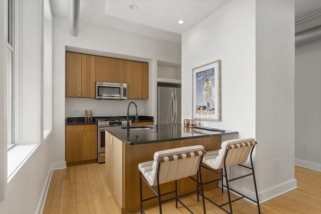 kitchen featuring a breakfast bar, kitchen peninsula, sink, and stainless steel appliances