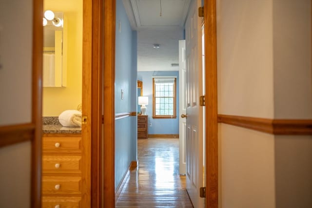 hall with attic access and wood finished floors