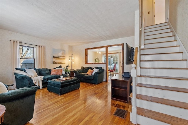 living room with a baseboard radiator and light hardwood / wood-style flooring