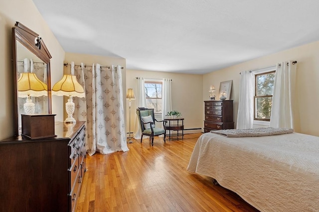 bedroom with multiple windows and light hardwood / wood-style flooring