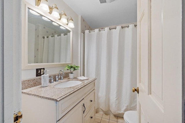 bathroom featuring toilet, tile patterned flooring, and vanity