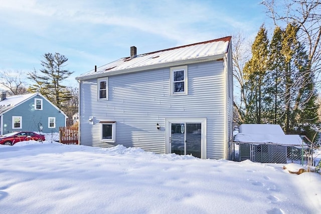 view of snow covered back of property