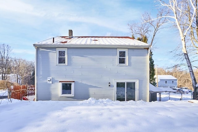 view of snow covered rear of property