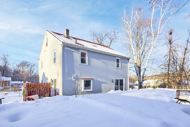 view of snow covered back of property