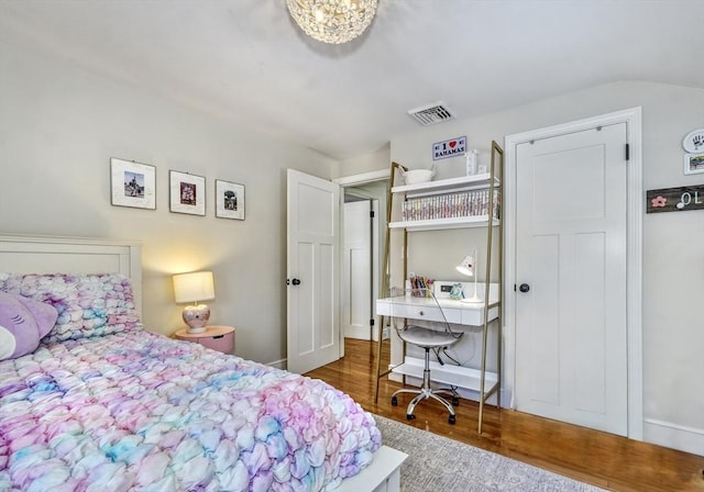 bedroom featuring dark hardwood / wood-style flooring and a chandelier