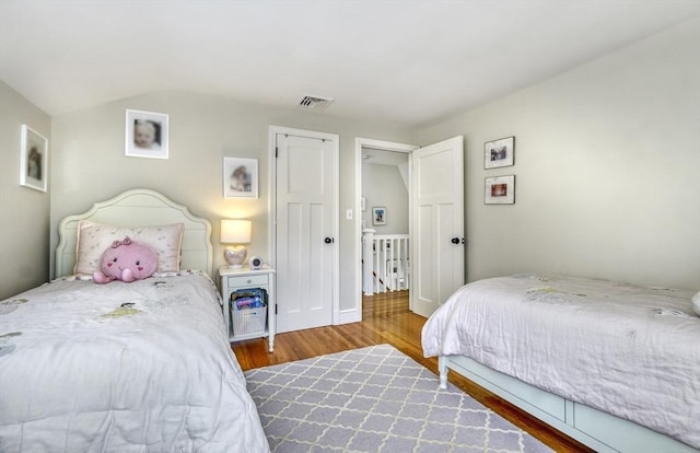 bedroom with lofted ceiling and hardwood / wood-style floors