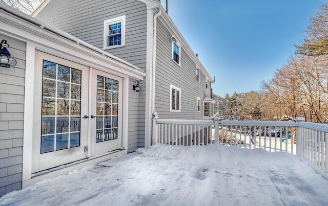 snow covered deck with french doors