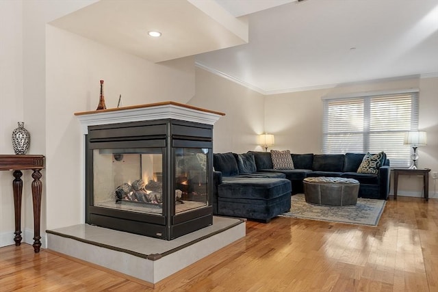 living room featuring hardwood / wood-style floors, a multi sided fireplace, and crown molding