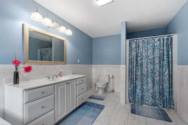 bathroom featuring vanity, toilet, and tile walls