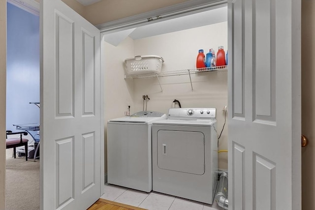 laundry room featuring washing machine and dryer and light tile patterned floors