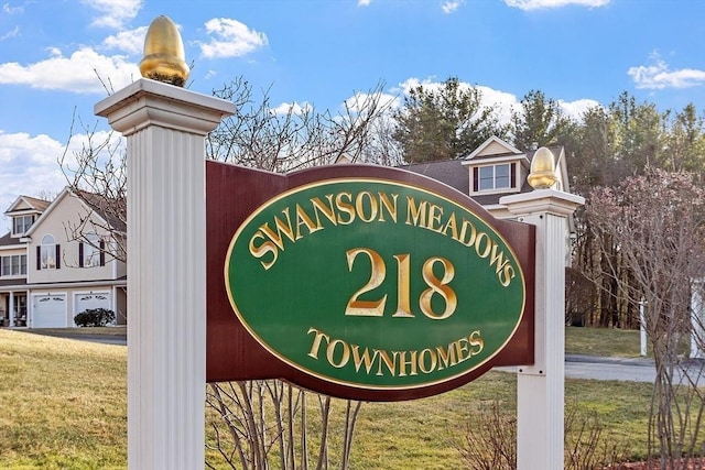 community / neighborhood sign with a yard