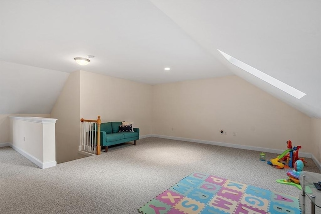 interior space featuring lofted ceiling with skylight and carpet floors