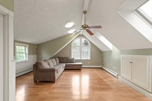 14 Prince St, Danvers, MA 01923 - living area featuring a baseboard radiator, light wood finished floors, vaulted ceiling, ceiling fan, and a skylight
