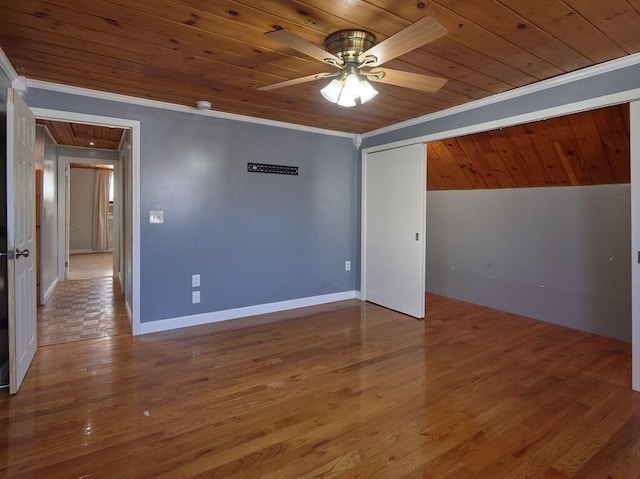 empty room featuring ceiling fan, ornamental molding, hardwood / wood-style floors, and wooden ceiling