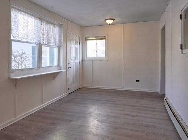 spare room with wood-type flooring and baseboard heating