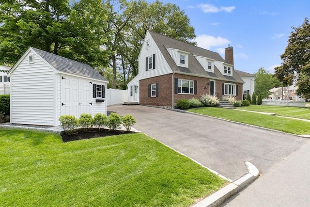 71 Sheffield Rd, Melrose, MA 02176 - view of front of house with brick siding, a chimney, an outbuilding, and roof with shingles