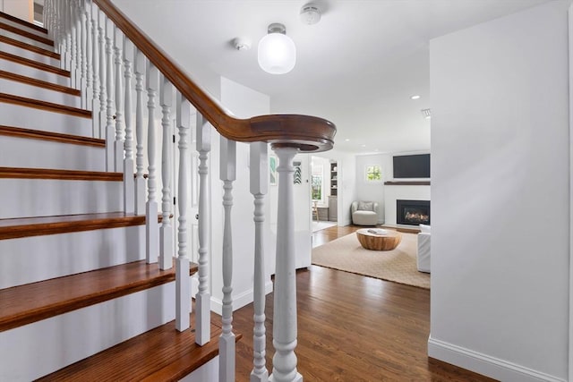 71 Sheffield Rd, Melrose, MA 02176 - staircase with wood finished floors, baseboards, and a warm lit fireplace
