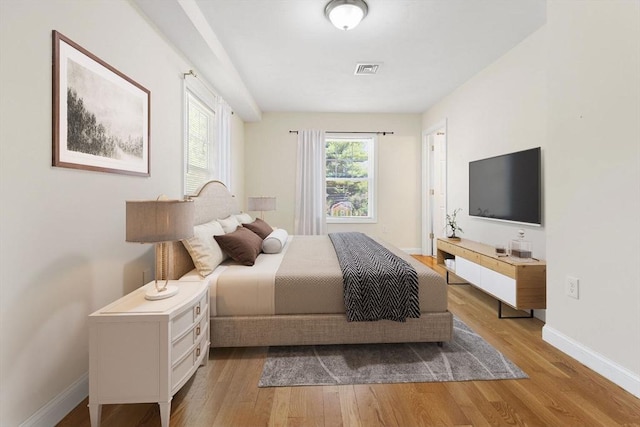 bedroom featuring baseboards, visible vents, and light wood-style floors