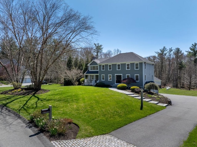 colonial-style house with a chimney and a front yard