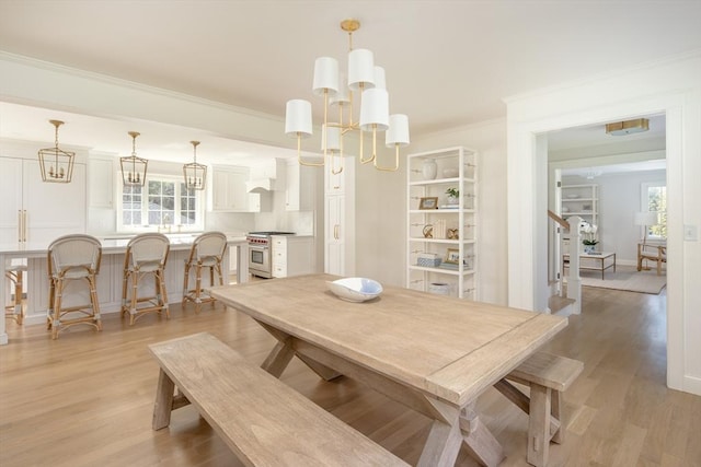 dining room featuring plenty of natural light, light wood-type flooring, and a notable chandelier