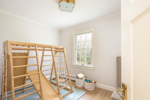 bedroom with baseboards, crown molding, and wood finished floors