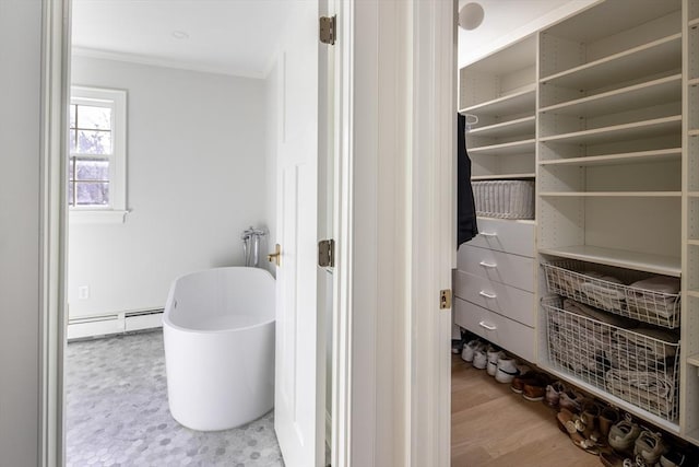 full bathroom featuring crown molding, a freestanding tub, wood finished floors, and baseboard heating