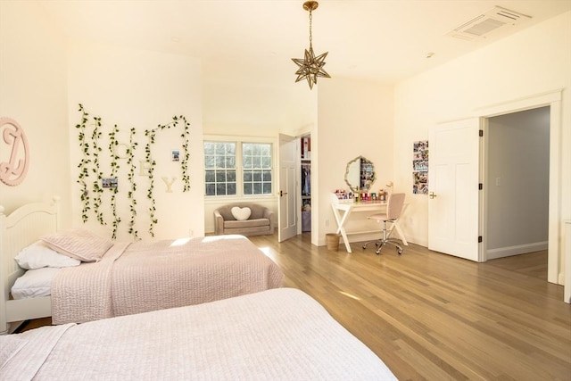 bedroom with visible vents, baseboards, a closet, light wood finished floors, and a spacious closet