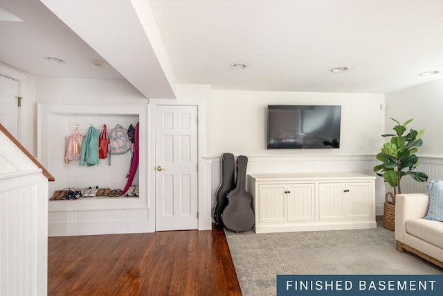 living room with recessed lighting, wainscoting, wood finished floors, and a decorative wall