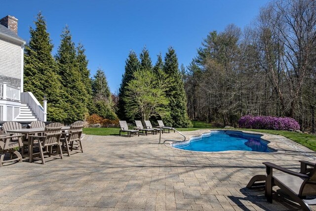 pool featuring stairs and a patio area