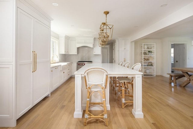 kitchen featuring light countertops, white cabinets, and high end range
