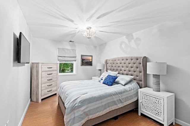 bedroom with a notable chandelier and hardwood / wood-style flooring