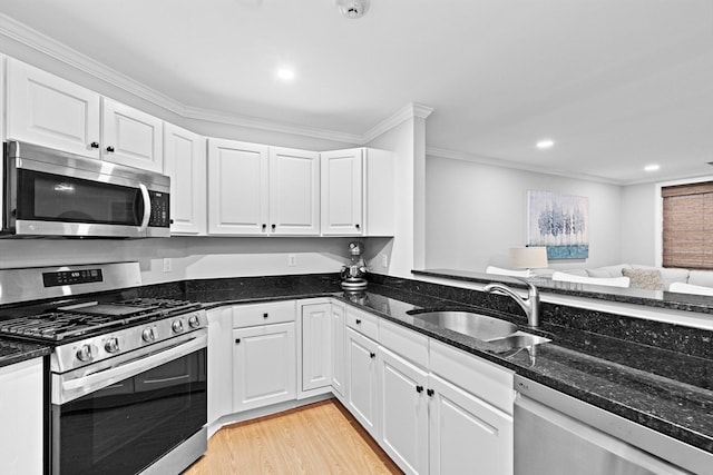 kitchen featuring ornamental molding, sink, white cabinets, and stainless steel appliances