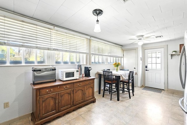 dining room featuring visible vents, baseboards, ceiling fan, and a toaster
