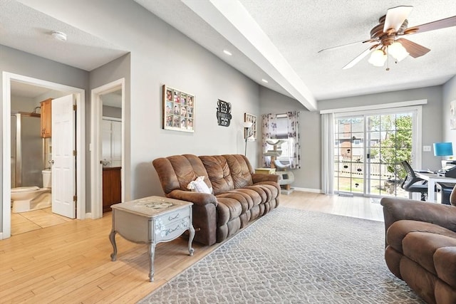living room with a ceiling fan, a textured ceiling, recessed lighting, and light wood finished floors