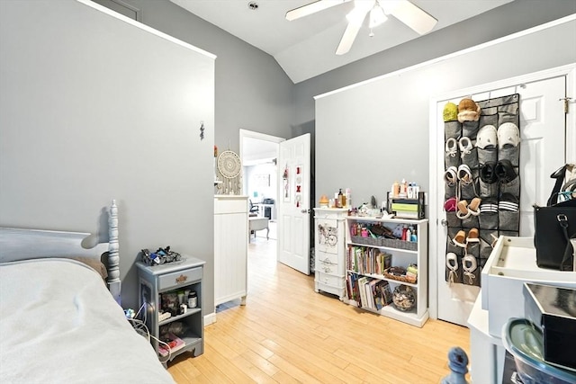 bedroom featuring a ceiling fan, vaulted ceiling, and light wood-style flooring