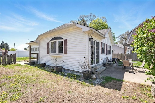 view of home's exterior with a lawn, a patio area, fence, and entry steps