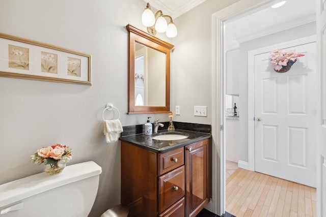 6 Hutchins Way, Westford, MA 01886 - half bathroom with ornamental molding, toilet, vanity, and wood finished floors