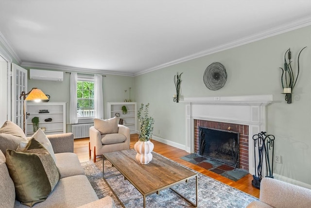 living area with a wall unit AC, radiator, ornamental molding, wood finished floors, and a brick fireplace