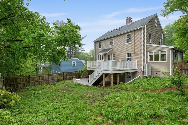 rear view of property with stairs, a wooden deck, fence, and a chimney