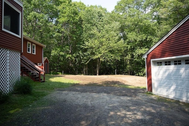 8 Adams Rd, Hubbardston, MA 01452 - view of yard with an outbuilding, driveway, a garage, stairway, and a forest view