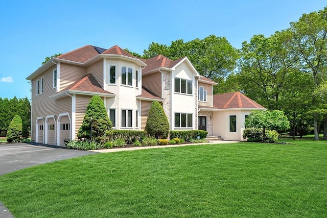 14 Sandpiper Hl, Sharon, MA 02067 - view of front of house featuring a garage, driveway, a front lawn, stucco siding, and a shingled roof